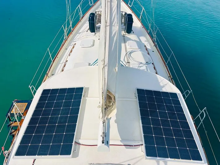  Yacht Photos Pics 1984 Irwin Cutter Ketch sailboat with solar panels on deck, floating on turquoise water.