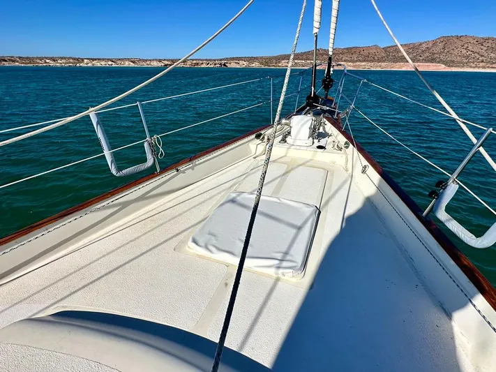  Yacht Photos Pics 1984 Irwin Cutter Ketch sailboat on calm blue waters, clear sky, coastal landscape.