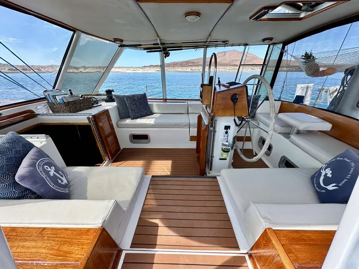  Yacht Photos Pics 1984 Irwin Cutter Ketch interior with wooden flooring and nautical-themed cushions.