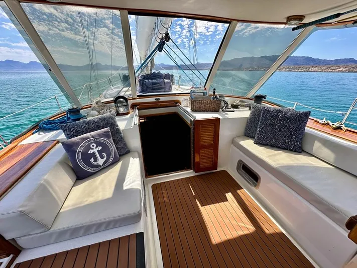  Yacht Photos Pics 1984 Irwin Cutter Ketch sailboat interior with cushioned seating and ocean view.