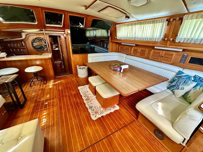  Yacht Photos Pics Interior of 1984 Irwin Cutter Ketch yacht with wooden flooring and cozy seating area.