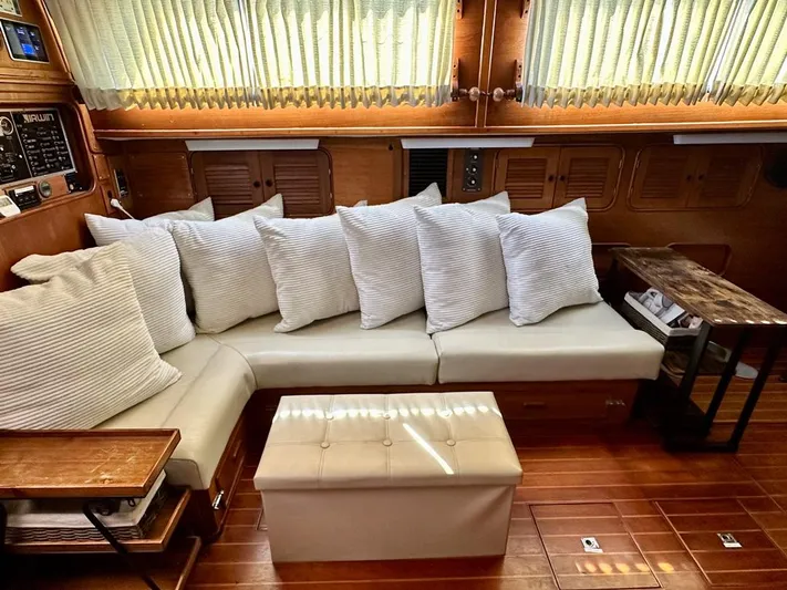  Yacht Photos Pics Interior of 1984 Irwin Cutter Ketch yacht with cushioned seating and wooden accents.