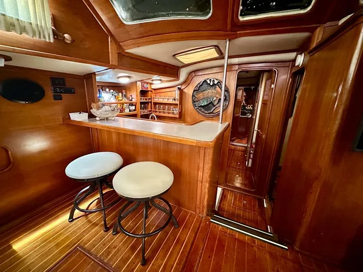  Yacht Photos Pics 1984 Irwin Cutter Ketch interior with wooden bar, stools, and nautical decor.