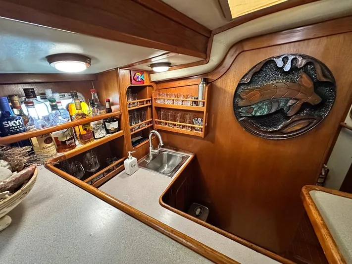  Yacht Photos Pics 1984 Irwin Cutter Ketch interior with wooden cabinetry, bar area, and decorative wall art.
