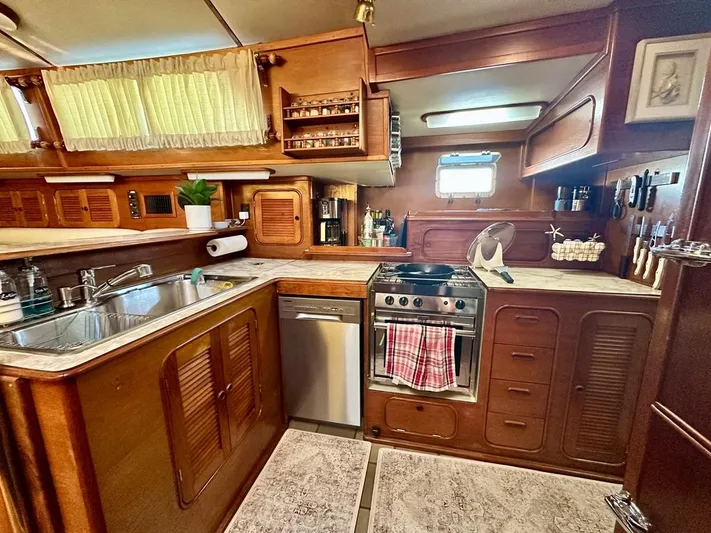  Yacht Photos Pics 1984 Irwin Cutter Ketch yacht kitchen with wooden cabinetry and modern appliances.