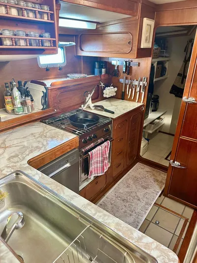  Yacht Photos Pics 1984 Irwin Cutter Ketch kitchen with wooden cabinetry, marble countertops, and stainless steel appliances.