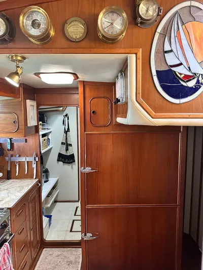  Yacht Photos Pics 1984 Irwin Cutter Ketch interior with wood paneling, nautical instruments, and stained glass art.
