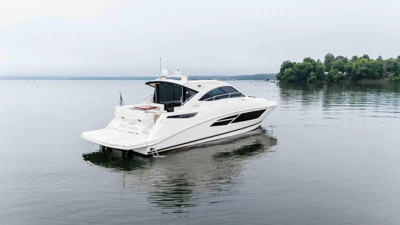  Yacht Photos Pics 2013 Sea Ray 510 Sundancer yacht on calm water, surrounded by trees.