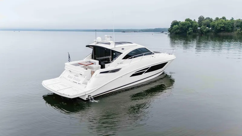  Yacht Photos Pics 2013 Sea Ray 510 Sundancer yacht on calm water, surrounded by trees.