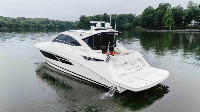  Yacht Photos Pics 2013 Sea Ray 510 Sundancer yacht cruising on a serene lake with lush green surroundings.