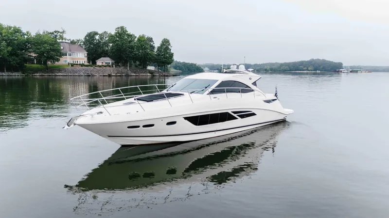  Yacht Photos Pics 2013 Sea Ray 510 Sundancer yacht cruising on a calm lake near shoreline homes.