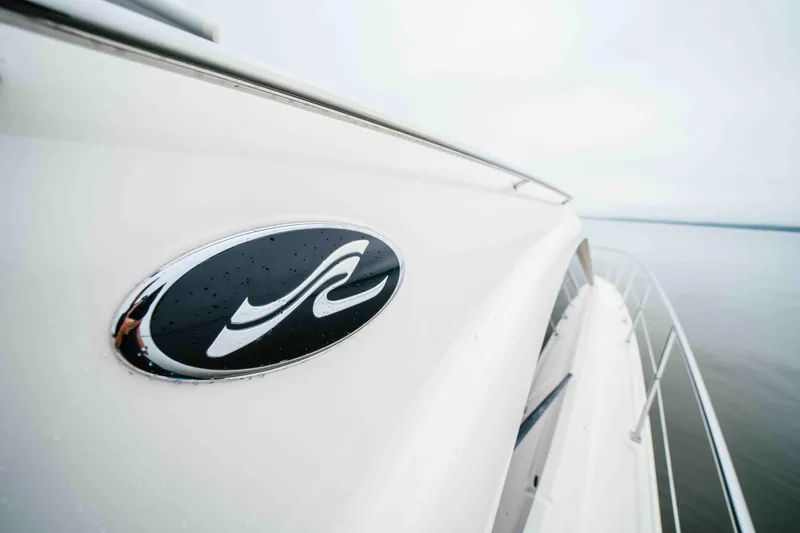  Yacht Photos Pics 2013 Sea Ray 510 Sundancer yacht on calm water, featuring sleek design and logo.