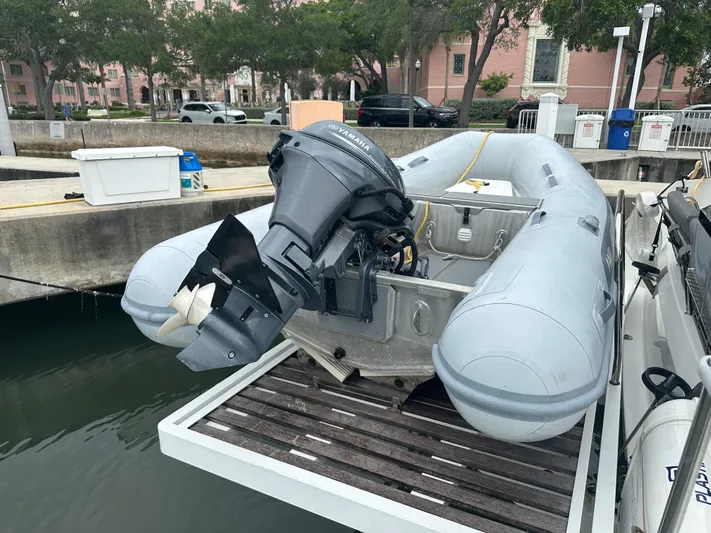 Brave Coquina Yacht Photos Pics Inflatable dinghy with outboard motor docked near a Fountaine Pajot Lucia 40, 2020 model.