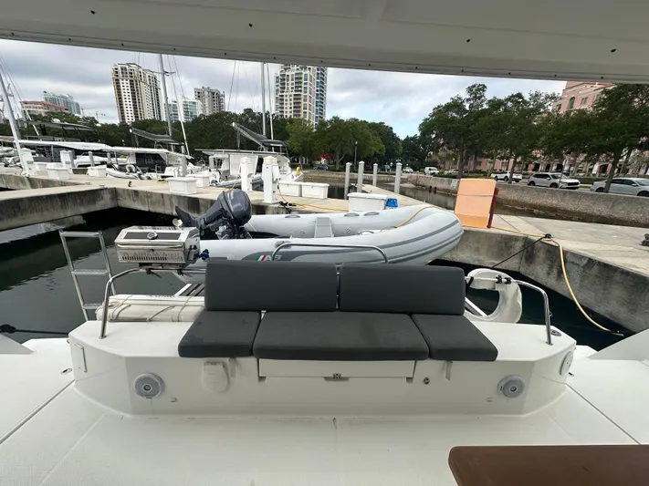 Brave Coquina Yacht Photos Pics Fountaine Pajot Lucia 40 catamaran, 2020 model, docked with an inflatable dinghy on the stern.