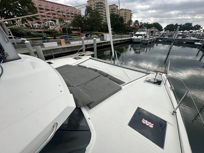 Brave Coquina Yacht Photos Pics 2020 Fountaine Pajot Lucia 40 catamaran docked at a marina with cityscape background.