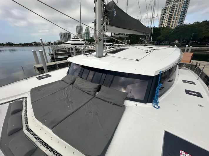 Brave Coquina Yacht Photos Pics 2020 Fountaine Pajot Lucia 40 catamaran docked at marina with cityscape background.