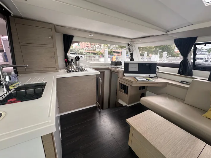Brave Coquina Yacht Photos Pics Modern interior of 2020 Fountaine Pajot Lucia 40 catamaran with kitchen and seating area.
