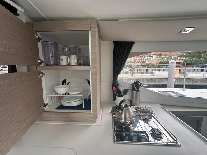 Brave Coquina Yacht Photos Pics Modern kitchen in 2020 Fountaine Pajot Lucia 40 catamaran with stove, kettle, and open cabinets.