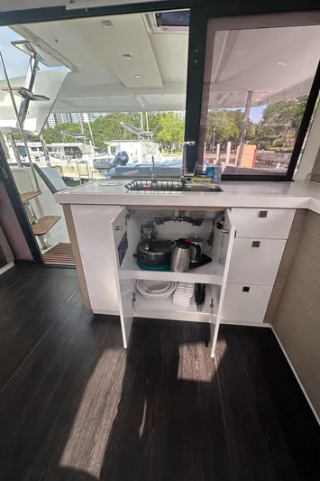 Brave Coquina Yacht Photos Pics Interior of 2020 Fountaine Pajot Lucia 40 catamaran with open kitchen cabinet.