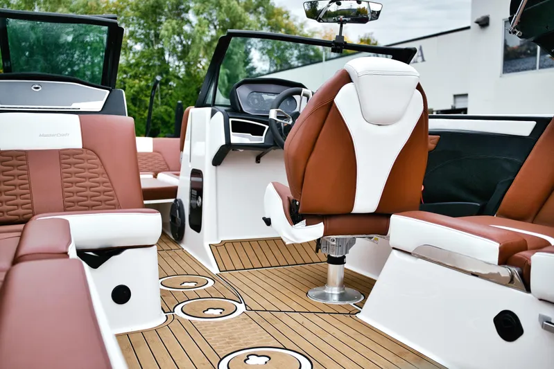  Yacht Photos Pics 2022 MasterCraft X24 boat interior with luxurious brown and white seating, modern dashboard.