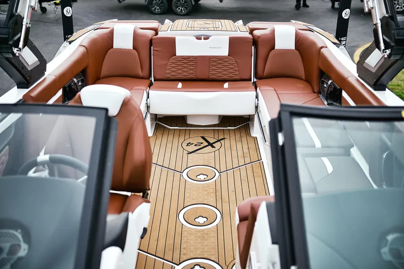  Yacht Photos Pics 2022 MasterCraft X24 boat interior with luxurious brown and white seating, teak-style flooring.