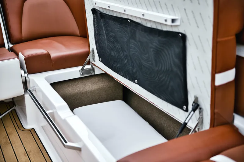  Yacht Photos Pics 2022 MasterCraft X24 boat interior storage compartment with brown seating and white accents.