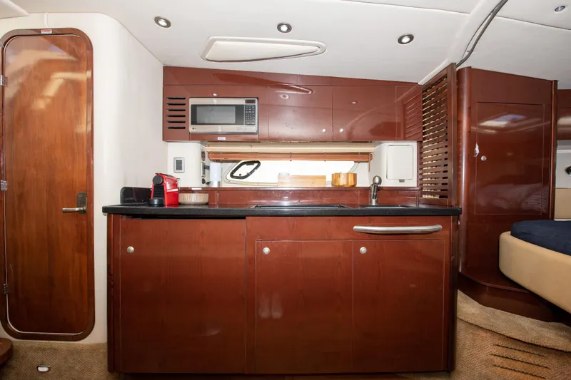  Yacht Photos Pics Interior kitchen of 2009 Sea Ray 350 Sundancer yacht with microwave and wooden cabinets.