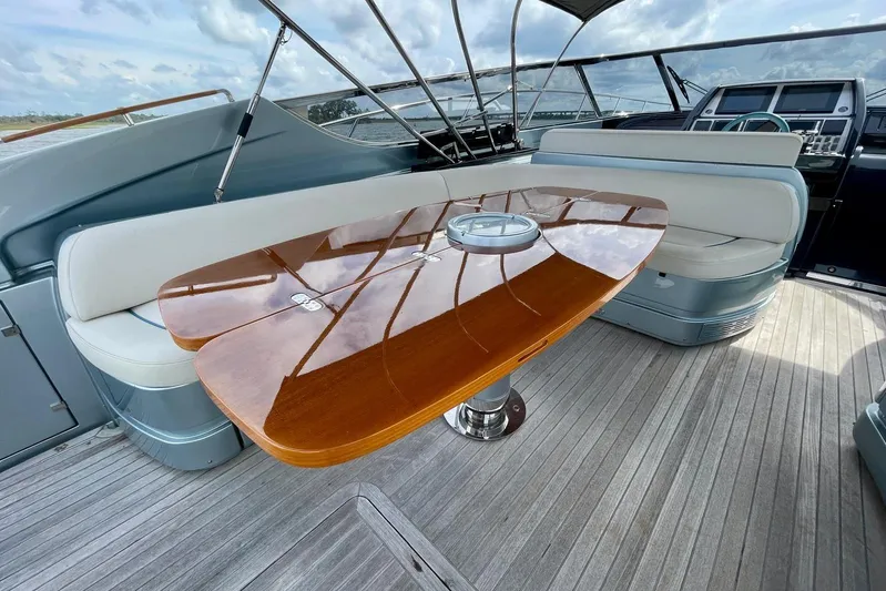 Andiamo Yacht Photos Pics Luxurious 2016 Riva 63 Virtus yacht interior with elegant wooden table and plush seating.