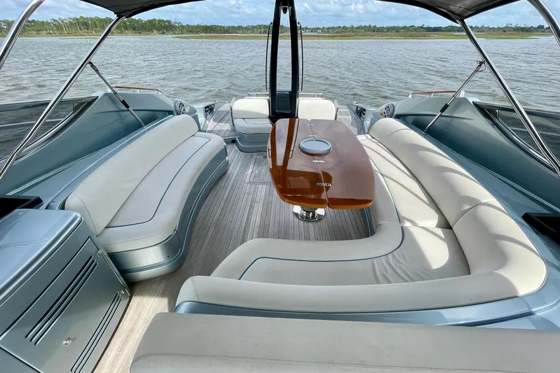 Andiamo Yacht Photos Pics Luxurious 2016 Riva 63 Virtus yacht interior with elegant seating and wooden table.