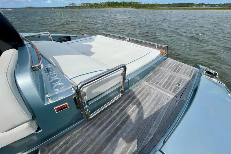 Andiamo Yacht Photos Pics 2016 Riva 63 Virtus yacht deck with sunbed, overlooking calm waters.