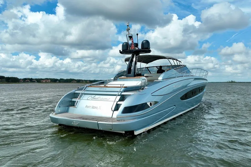 Andiamo Yacht Photos Pics 2016 Riva 63 Virtus yacht cruising on a calm, scenic waterway under a cloudy sky.