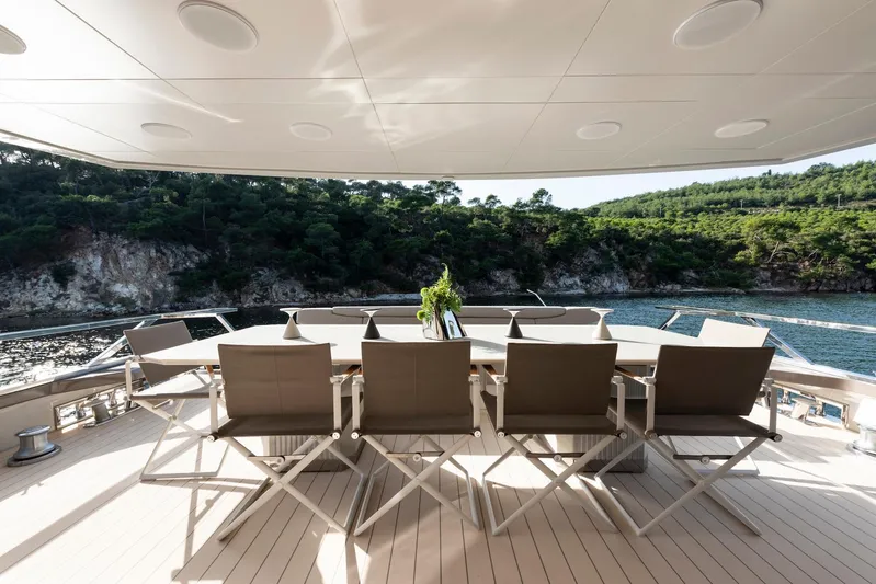  Yacht Photos Pics Luxury outdoor dining area on 2025 Mazu Yachts 92 DS, overlooking scenic coastal view.