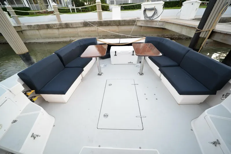 Miracle 2 Yacht Photos Pics Spacious seating area on 2006 True North 38 boat with blue cushions and wooden tables.