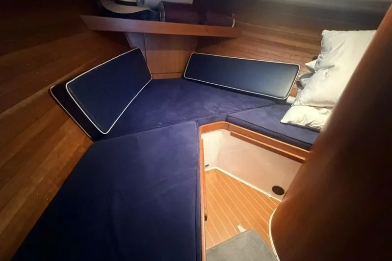 Miracle 2 Yacht Photos Pics Cozy cabin interior of 2006 True North 38 boat with blue cushions and wooden paneling.