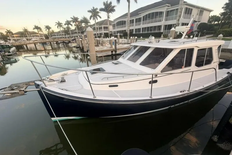 Miracle 2 Yacht Photos Pics 2006 True North 38 yacht docked at marina with palm trees and waterfront buildings.