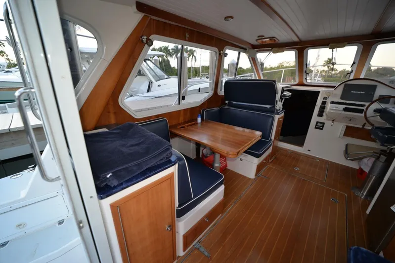 Miracle 2 Yacht Photos Pics Interior of 2006 True North 38 boat with wooden flooring and navy seating.