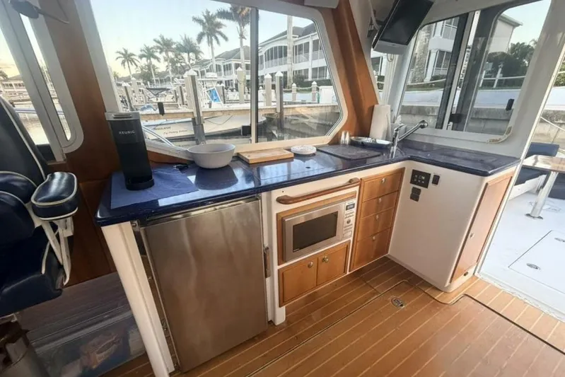 Miracle 2 Yacht Photos Pics Interior of 2006 True North 38 yacht with kitchenette, featuring blue countertops and wooden cabinetry.