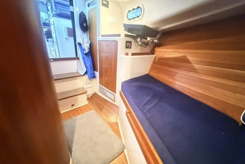 Miracle 2 Yacht Photos Pics Interior of 2006 True North 38 boat with wooden paneling and blue cushioned seating.