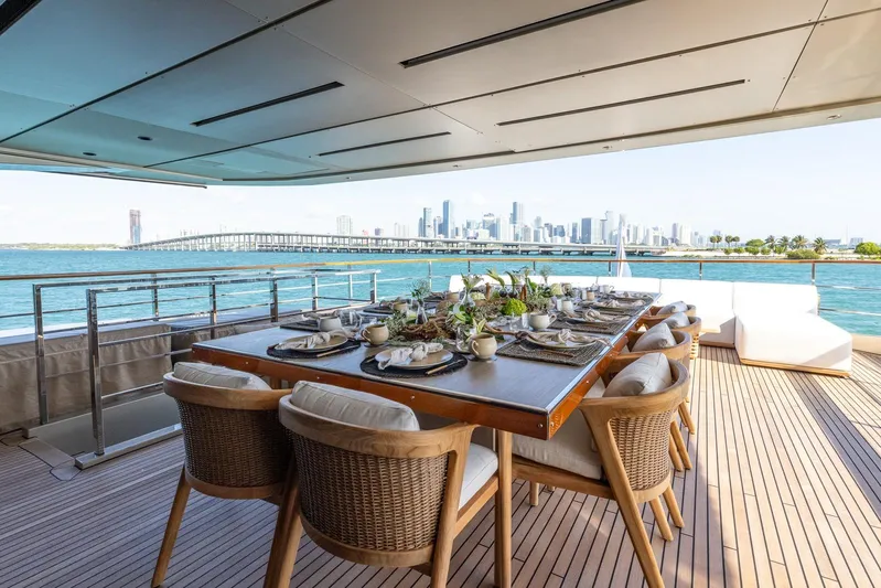 Maverick Yacht Photos Pics Luxurious dining area on Admiral Impero 40 yacht, overlooking city skyline and ocean.