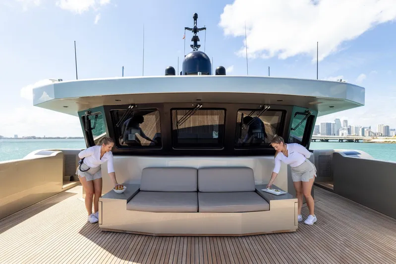 Maverick Yacht Photos Pics Luxury yacht Admiral Impero 40, 2013 model, with crew on deck, city skyline in background.