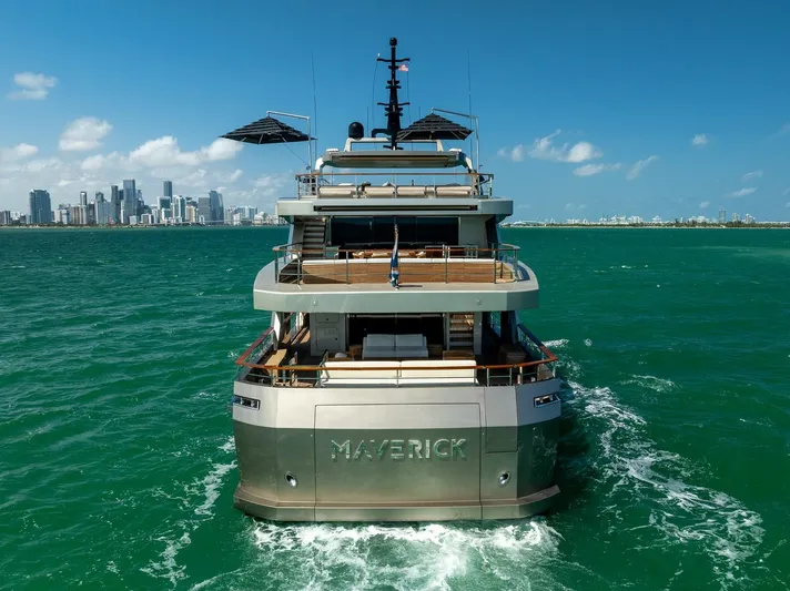 Maverick Yacht Photos Pics Luxury yacht Admiral Impero 40, 2013, cruising in turquoise waters near a city skyline.