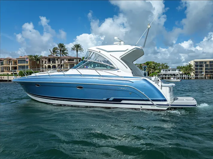  Yacht Photos Pics 2022 Formula 40 PC yacht cruising on a sunny day, with waterfront homes in the background.