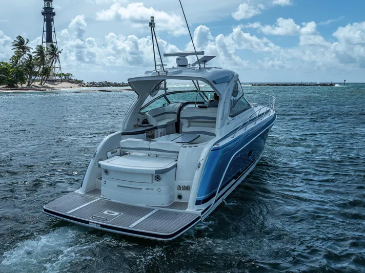  Yacht Photos Pics 2022 Formula 40 PC yacht cruising near a lighthouse on a sunny day.