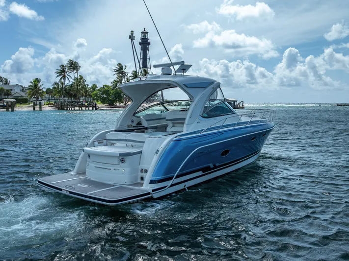 Yacht Photos Pics 2022 Formula 40 PC yacht cruising near tropical shoreline with lighthouse in background.