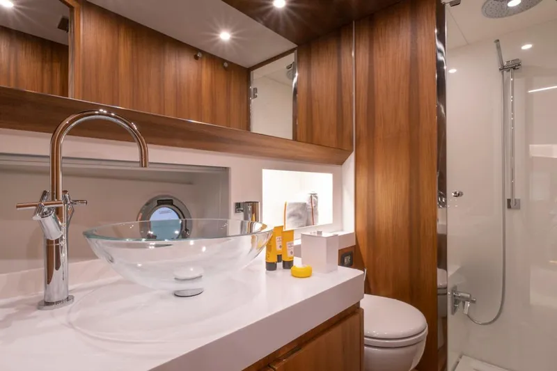  Yacht Photos Pics Luxurious bathroom in 2026 Solaris Power 48 Flybridge yacht with glass sink and wooden cabinetry.