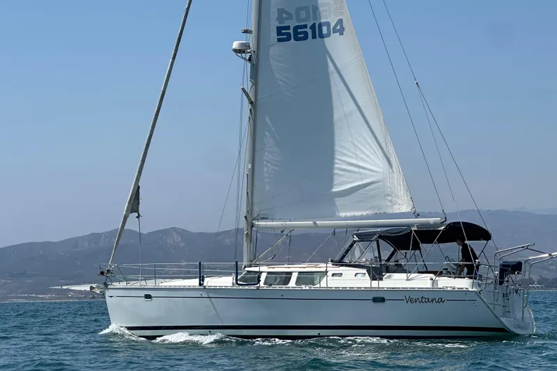  Yacht Photos Pics 2001 Jeanneau Sun Odyssey 43 DS sailing on open water with mountainous backdrop.