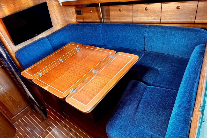  Yacht Photos Pics Luxurious interior of 2001 Jeanneau Sun Odyssey 43 DS with blue seating and wooden table.