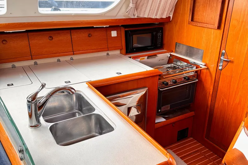  Yacht Photos Pics 2001 Jeanneau Sun Odyssey 43 DS yacht kitchen with sink, stove, and microwave.