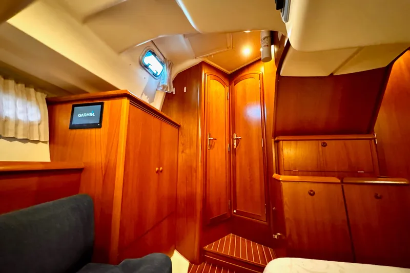  Yacht Photos Pics Interior of 2001 Jeanneau Sun Odyssey 43 DS yacht with wooden cabinetry and Garmin display.