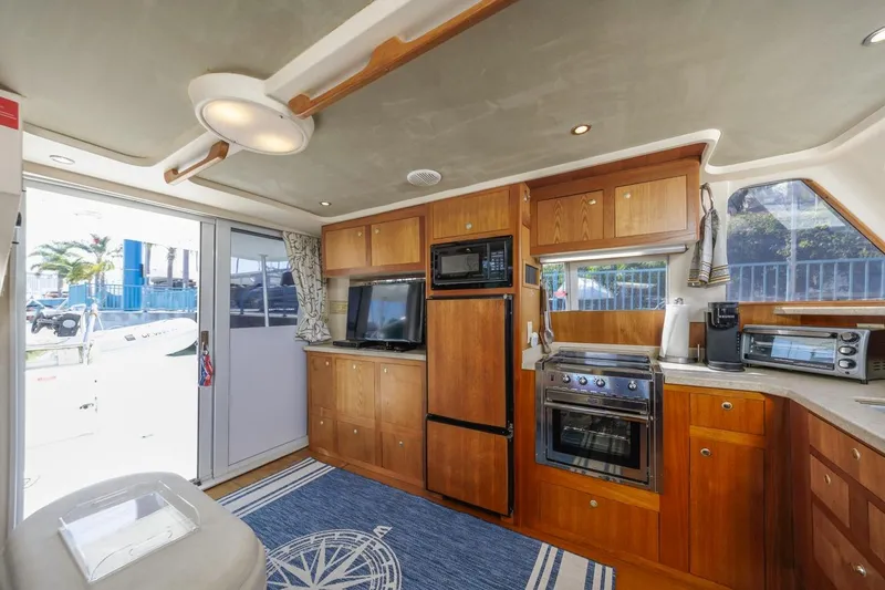 La Woman Yacht Photos Pics Interior of 2001 Mainship 390 Trawler with wooden cabinetry and modern kitchen appliances.